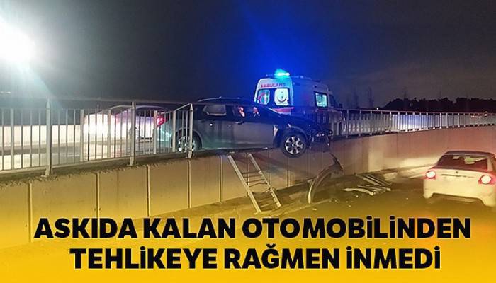 Bariyerlerde askıda kalan otomobilden düşme tehlikesine rağmen inmedi