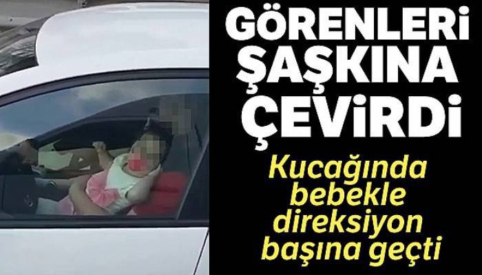 Kucağında bebek ile direksiyon başına geçen sürücü kamerada