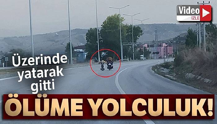 Motosiklet üstünde yatarak giden sürücü tehlike saçtı